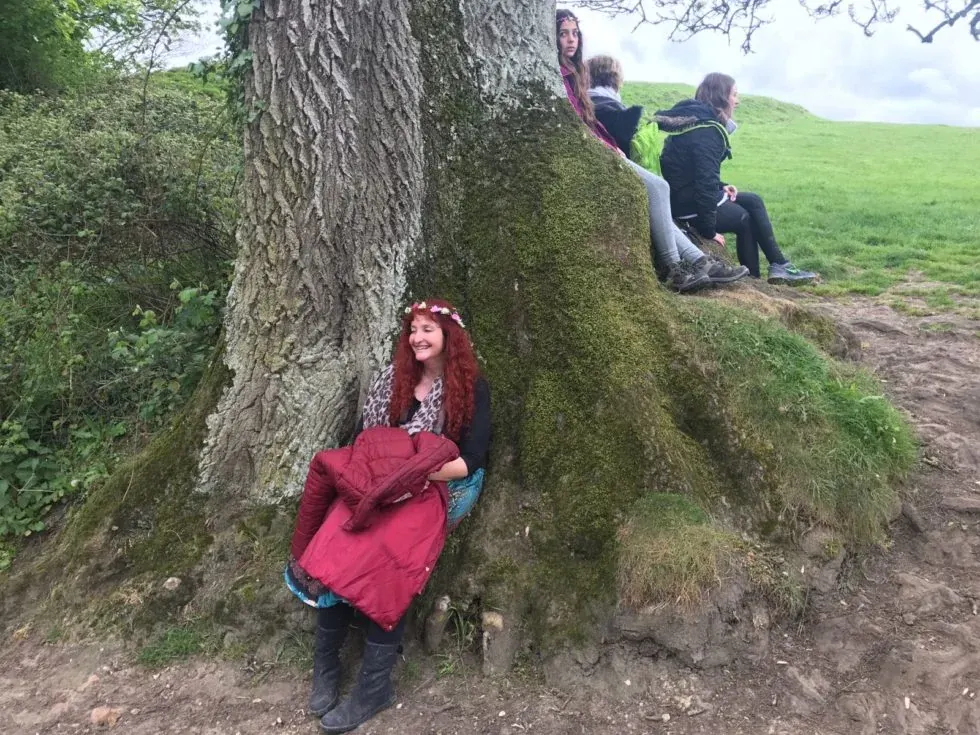 Raquel G. Eireen sentada junto a las raíces de un árbol
